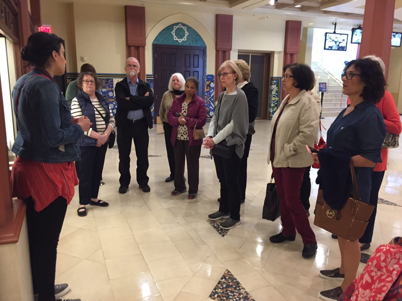 Tour group listening to guide in museum lobby