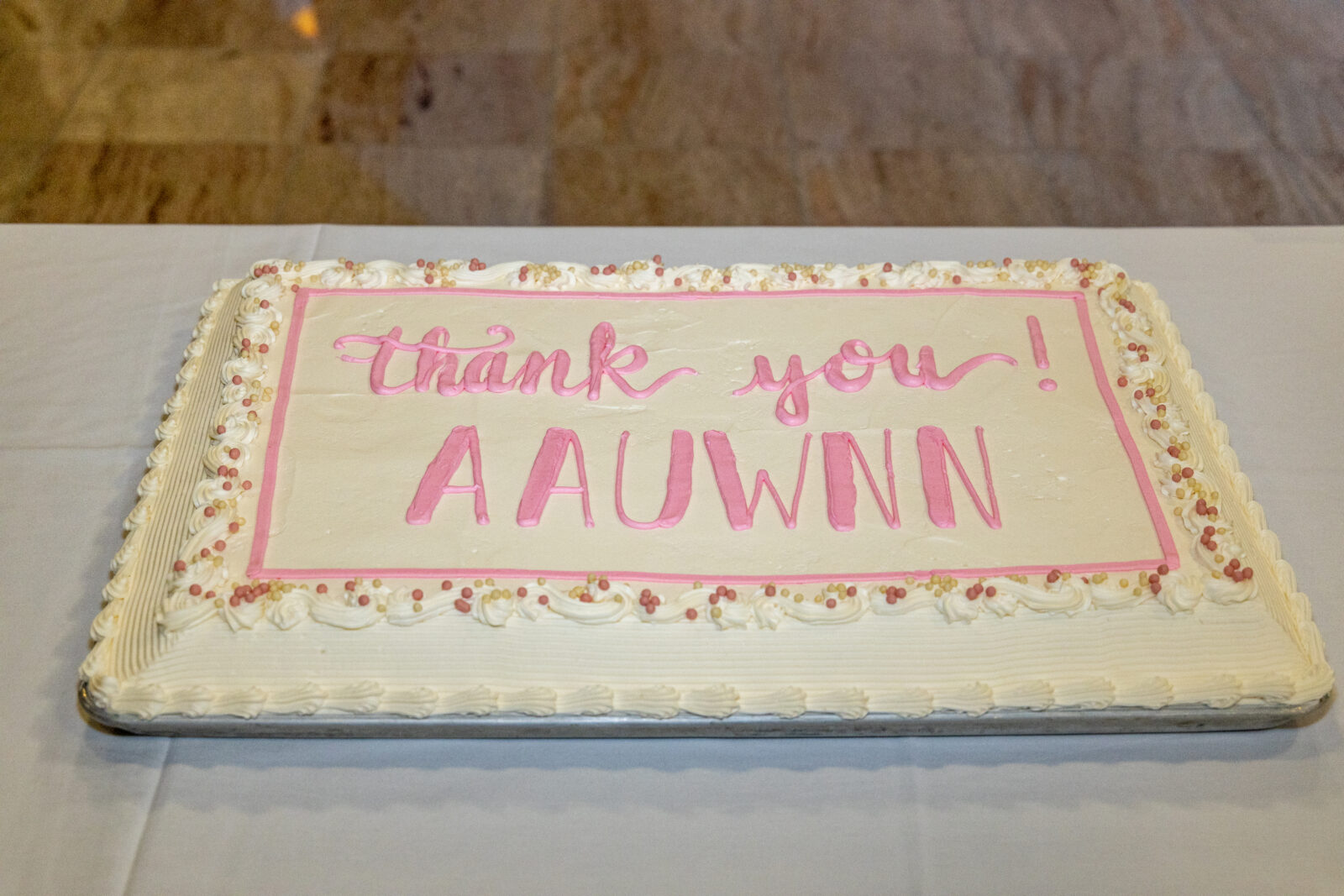 White sheet cake reading "thank you