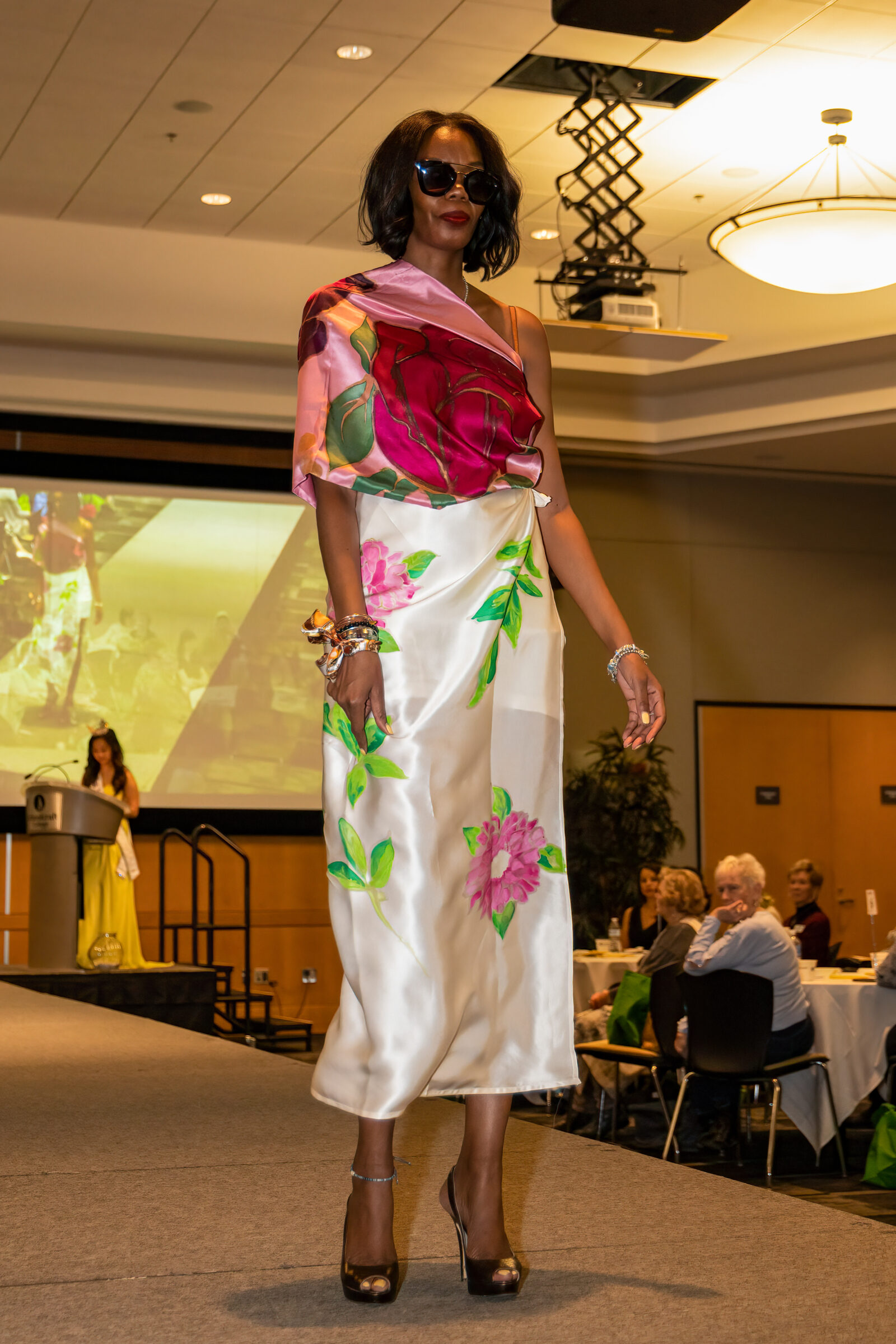 Woman modeling floral satin dress and sunglasses