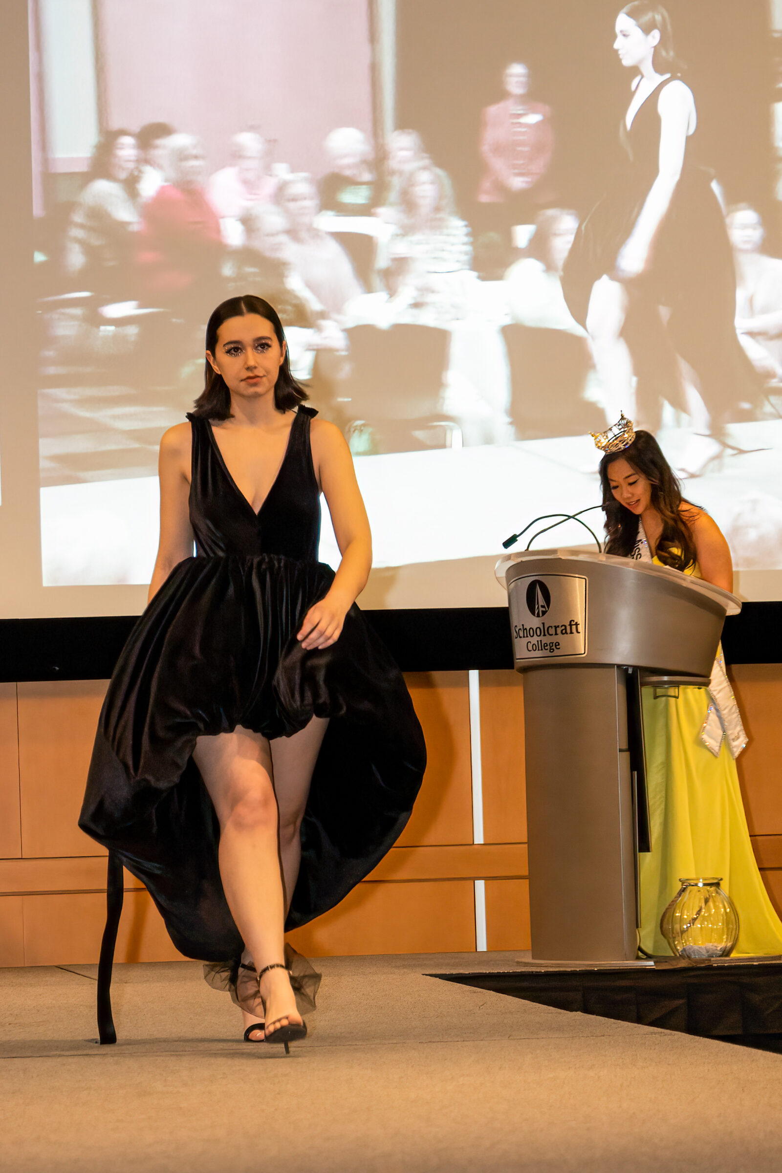 Model in black dress walking runway fashion show